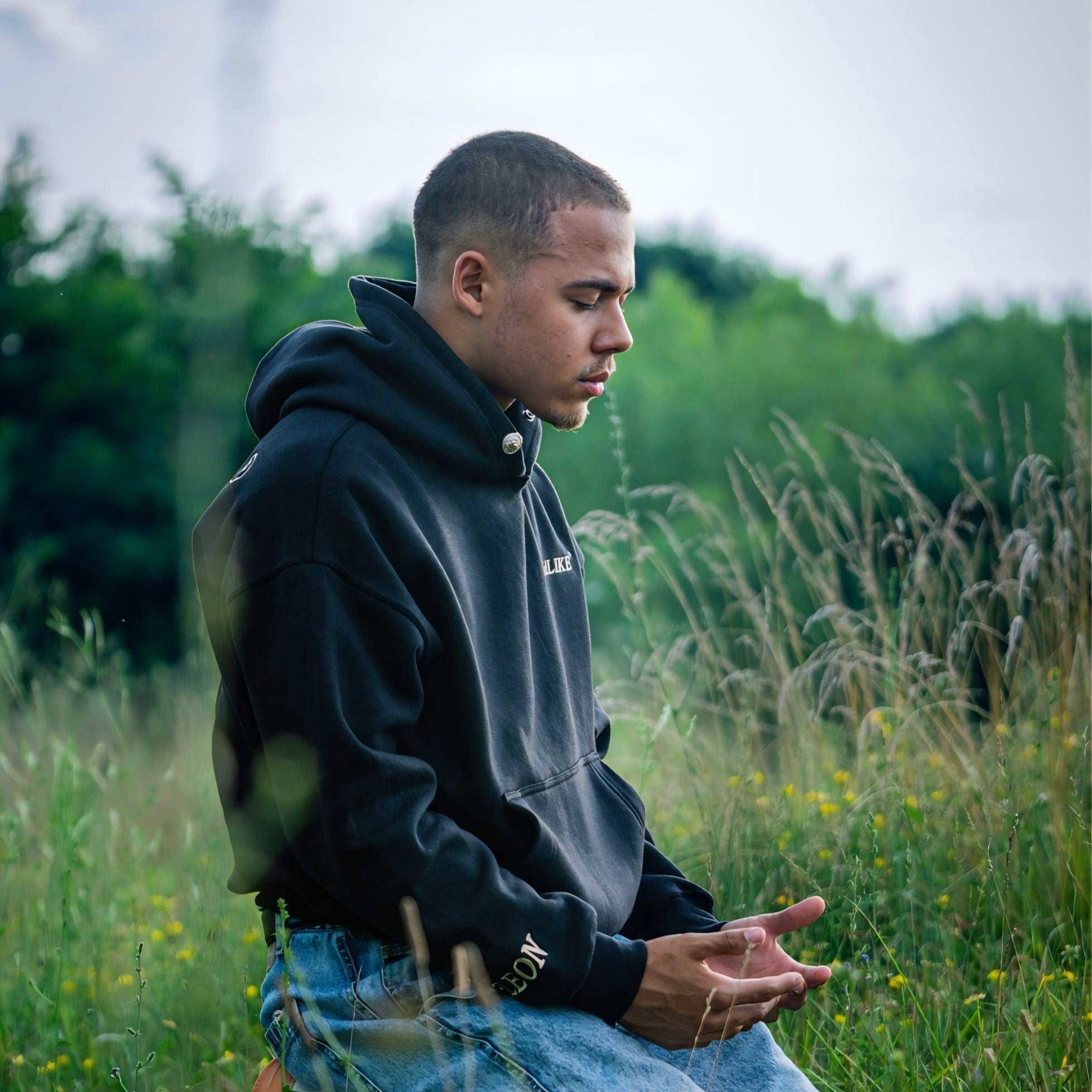 Person sitting on a chair in a grassy field with a blurred background